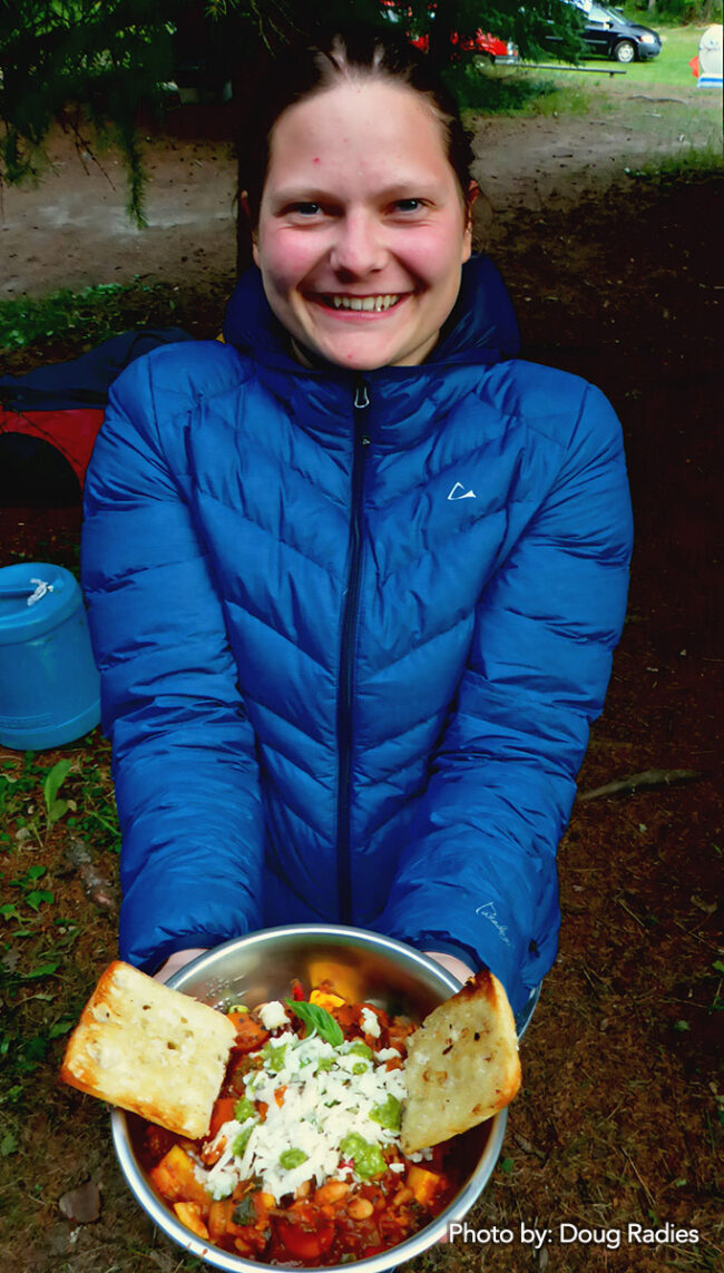 Sasha with a bowl full of delicious camp food.